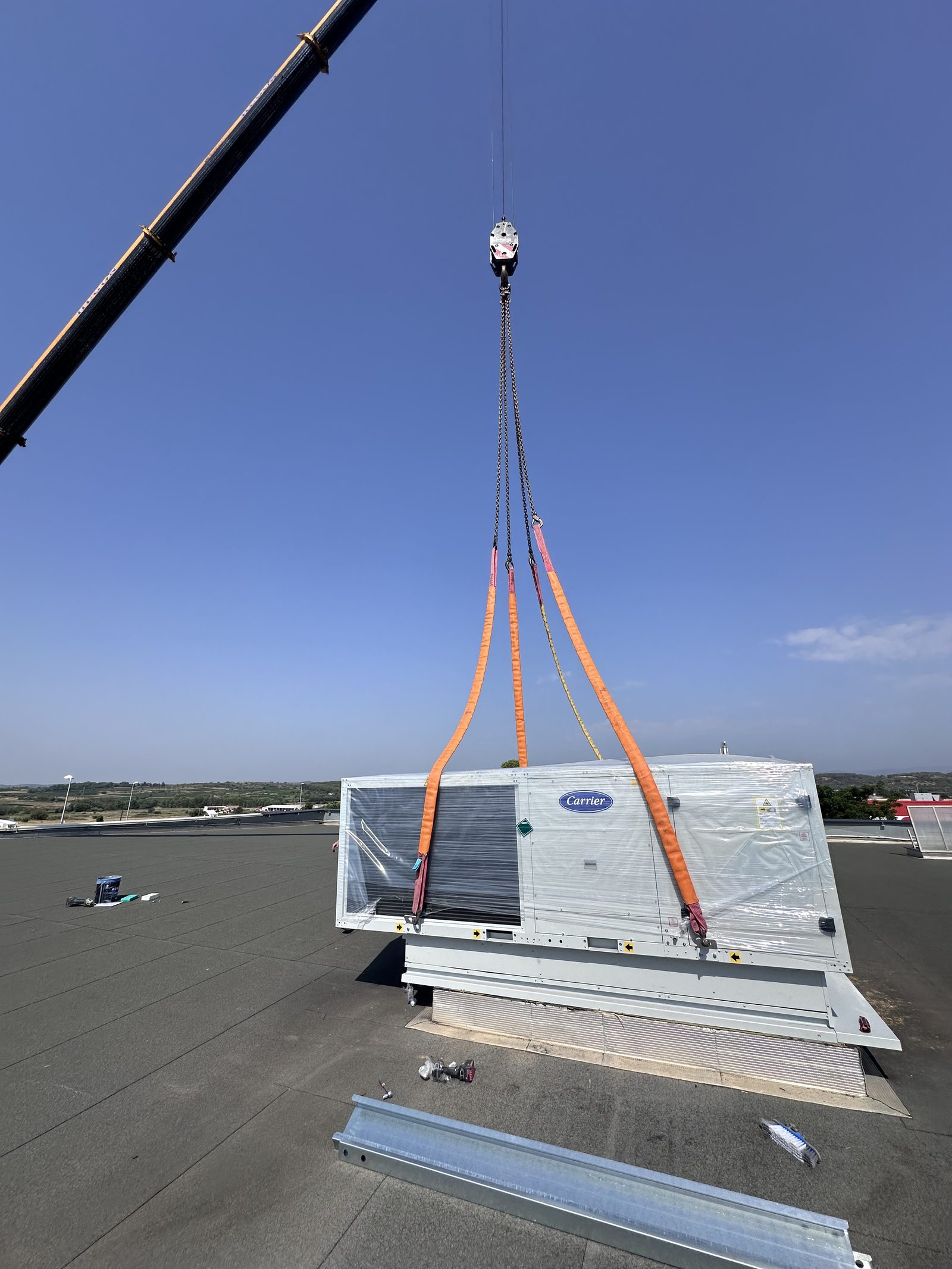 Levage à la grue d'un rooftop Carrier sur une toiture-terrasse