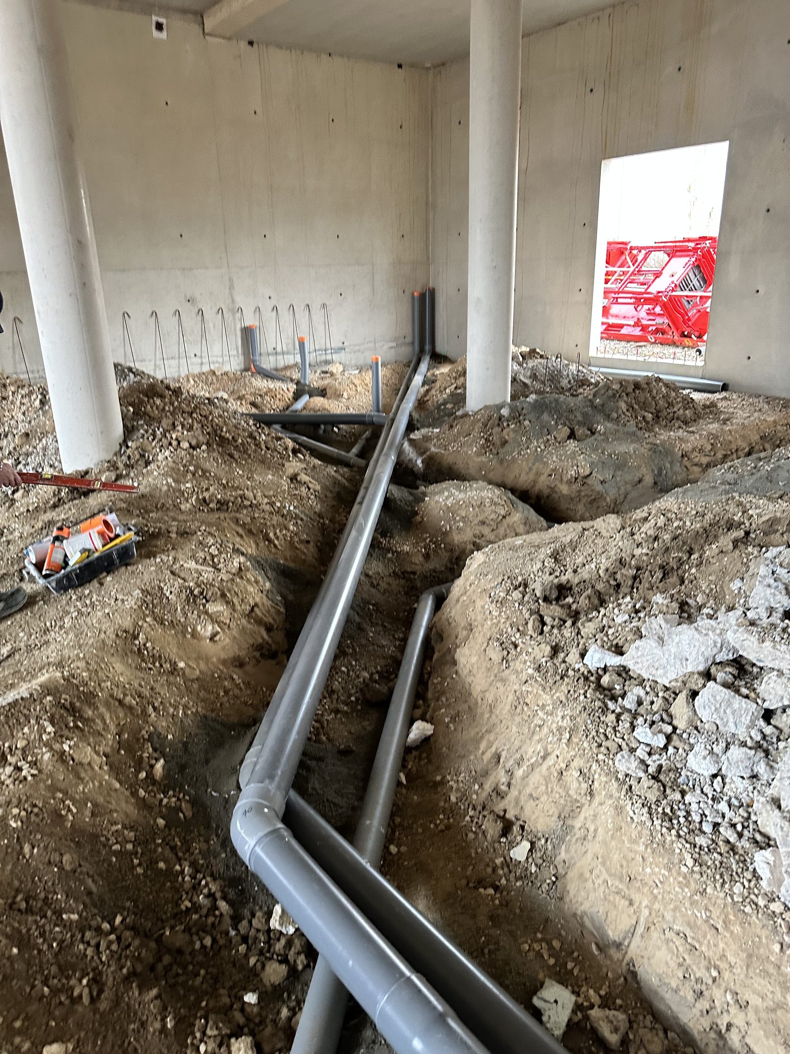 Réseaux d'évacuation PVC en tranchée, avec attentes verticales, dans un bâtiment en construction